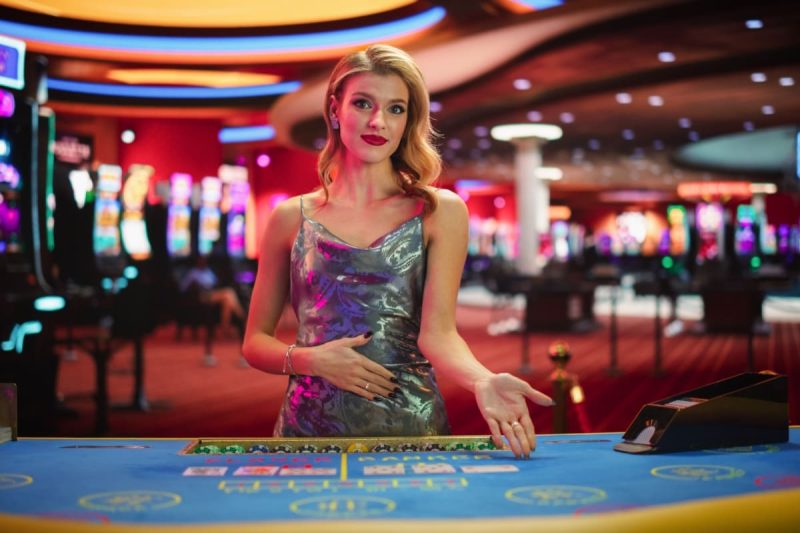 femeie crupier in fata unei mese de baccarat online live