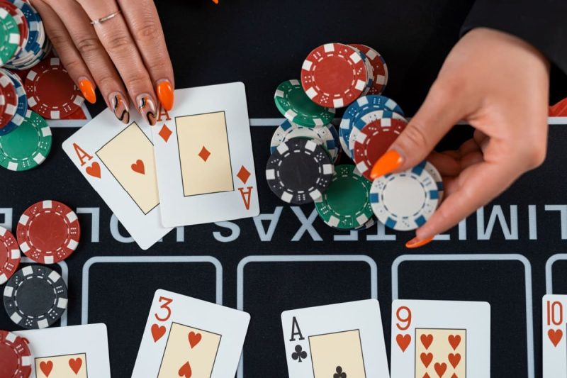 femeie in fata unei mese de poker aratand cartile din mana la finalul unei runde