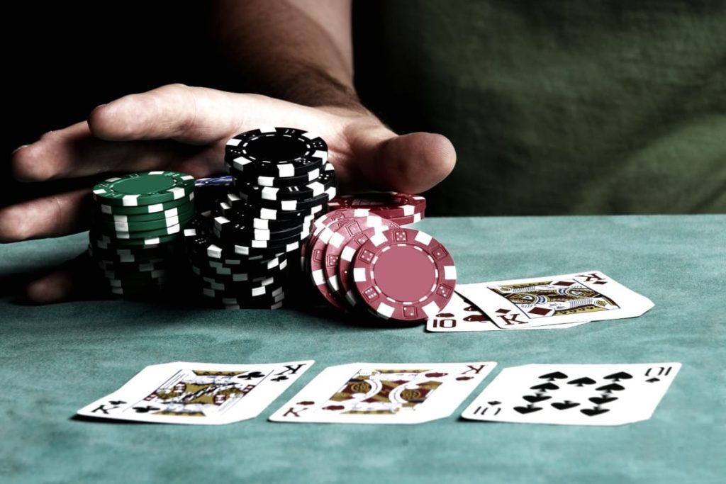 jucator de poker colectand jetoanele dupa o runda