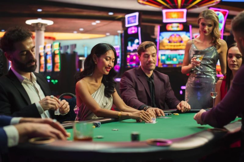 diversi jucatori in jurul unei mese de poker dintr-un cazino