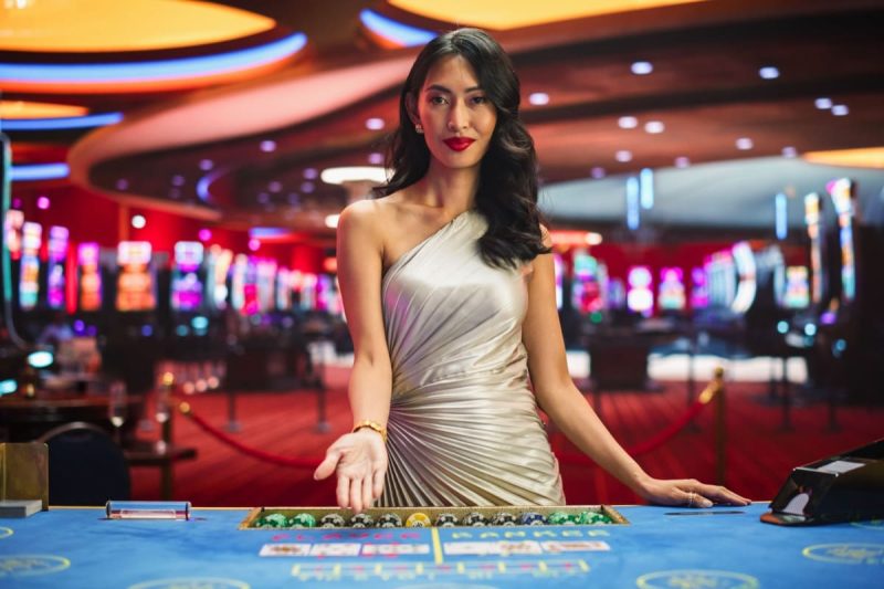 femeie crupier in fata unei mese de baccarat online live