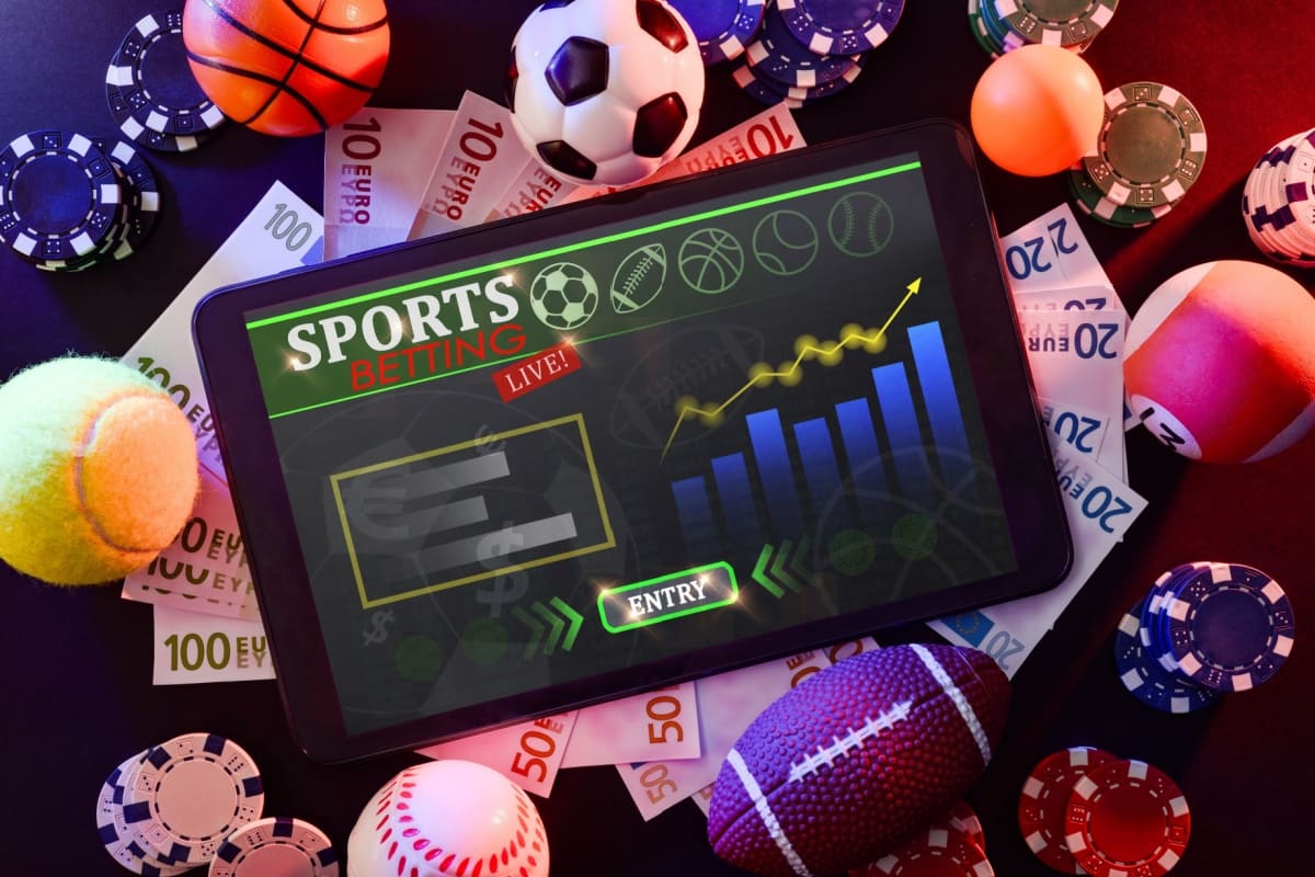 tableta inconjurata de diferite mingi specifice sporturilor disponibile la pariuri online