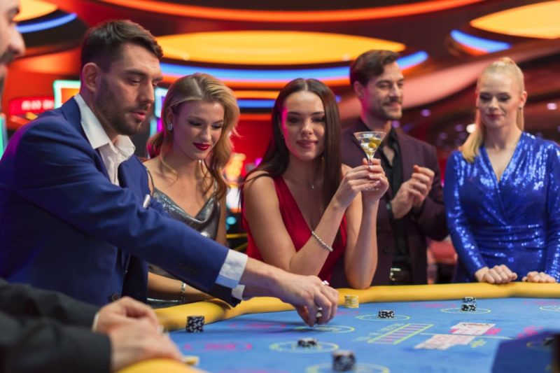 jucatori in timpul unei runde de baccarat in jurul unei mese dintr-un casino