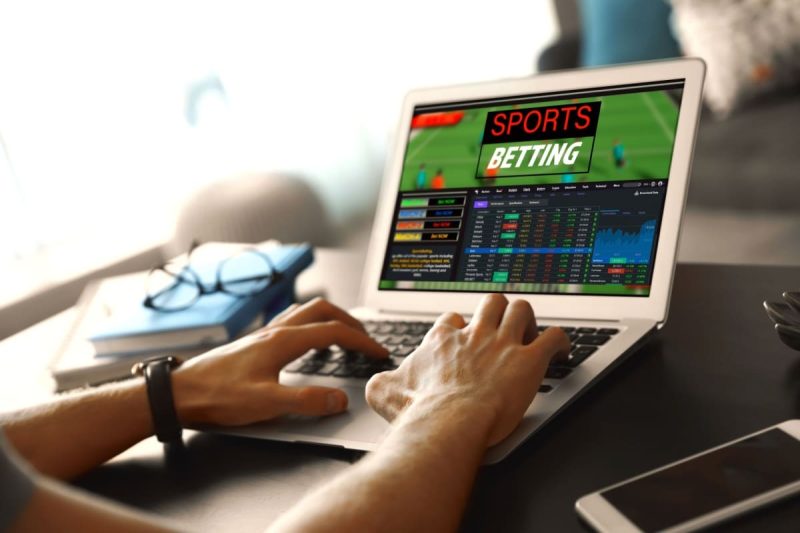 barbat urmarind statistici ale unui meci de fotbal pe o platforma de pariuri online