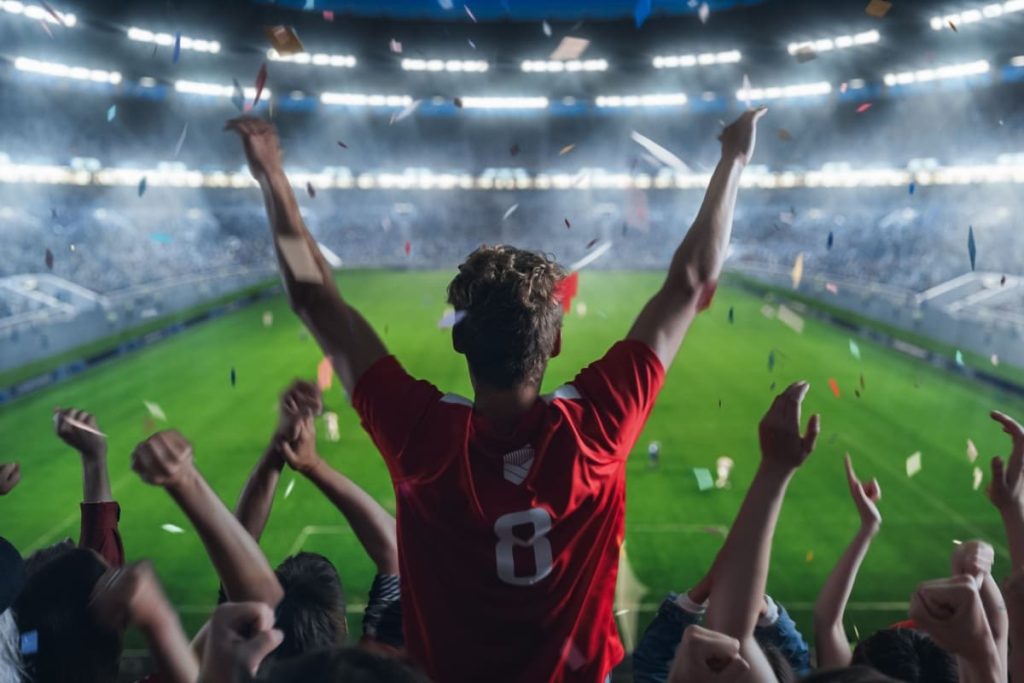 suporteri ai unei echipe de fotbal sarbatorind in tribune dupa un gol marcat