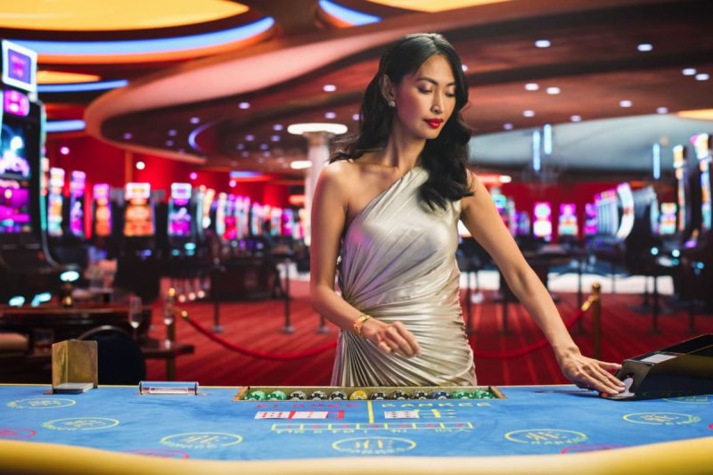 femeie crupier in timpul unui joc de baccarat cazino live online