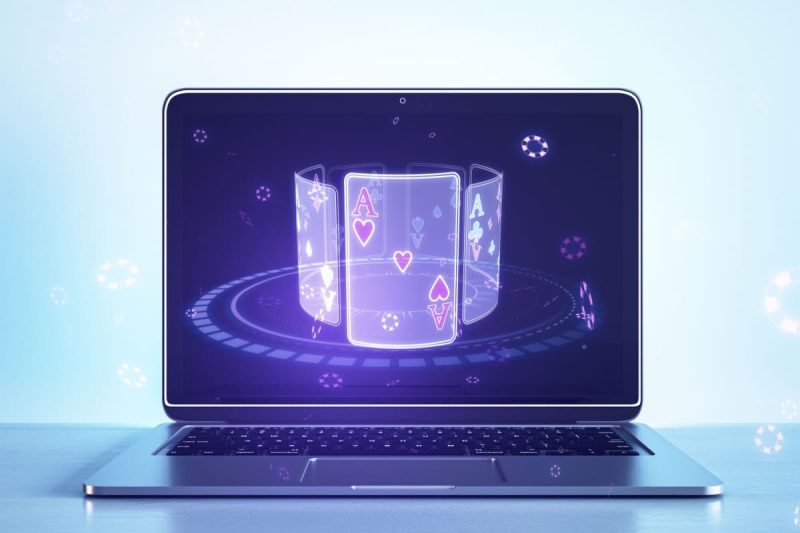 laptop cu patru asi si jetoane de cazino in culori neon pe ecran