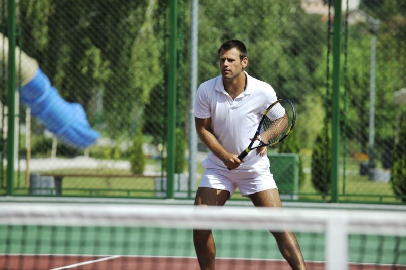barbat in timpul unui meci de tenis afara, pe teren de gzura