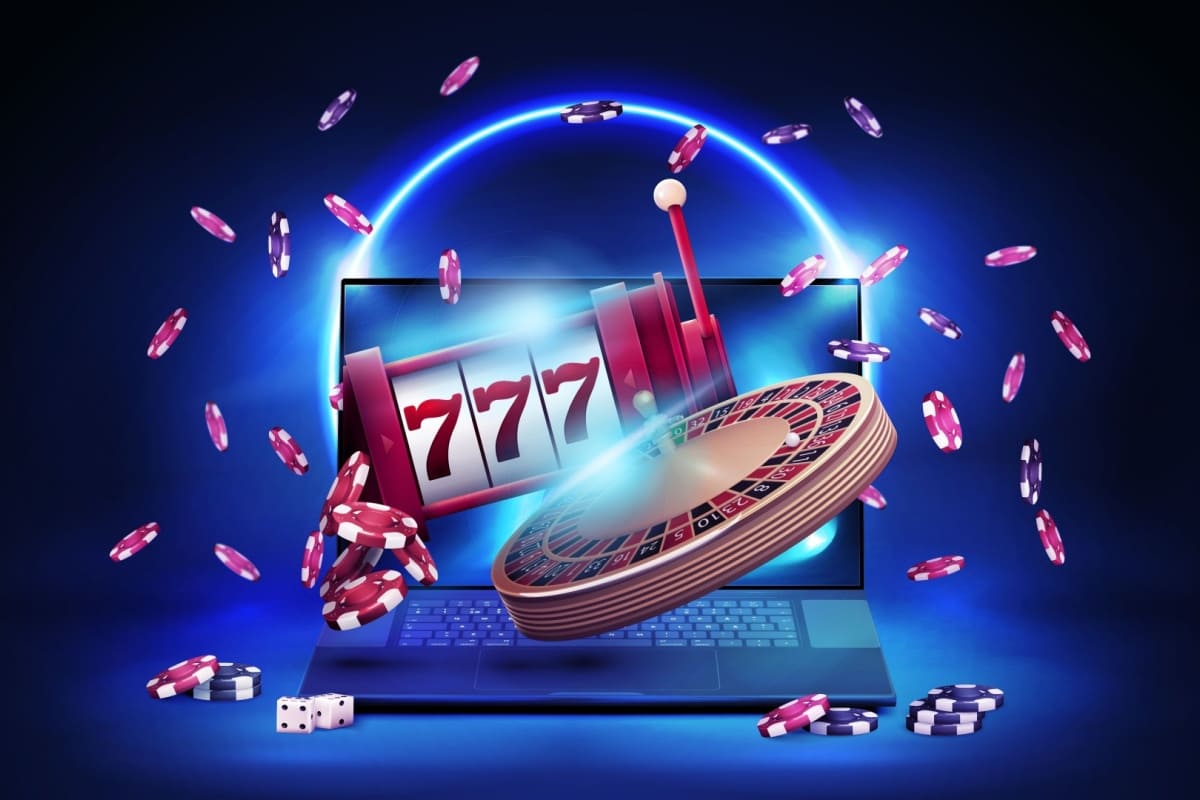 laptop cu o ruleta, un slot mecanic, zaruri si jetoane de cazino in jur