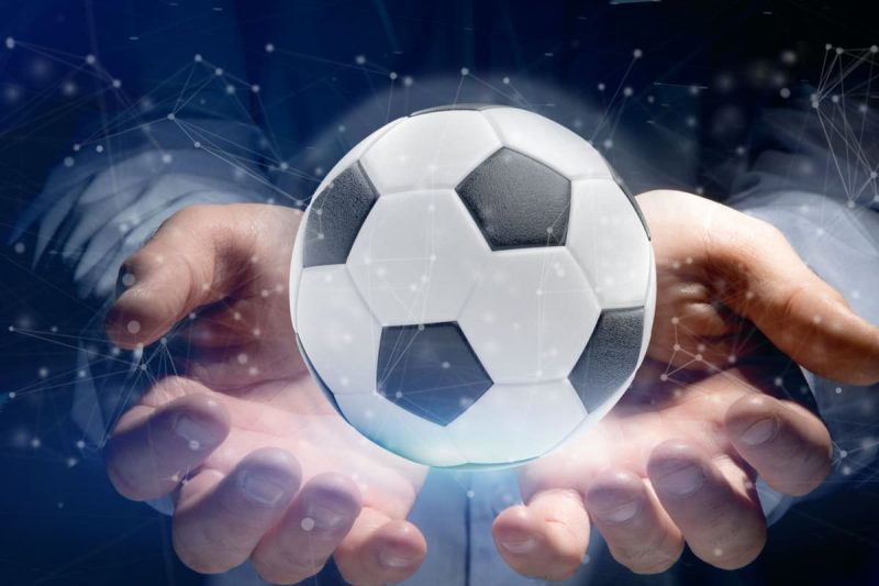barbat tinand in mana holograma unei mingi de fotbal