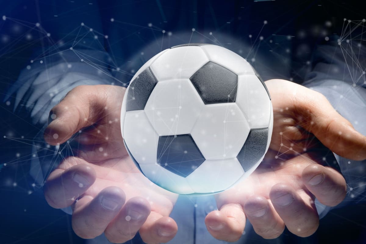 barbat tinand in mana holograma unei mingi de fotbal