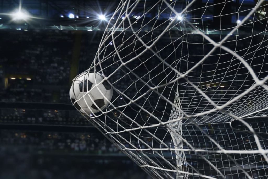 minge de fotbal in plasa portii, cu tribuna in fundal