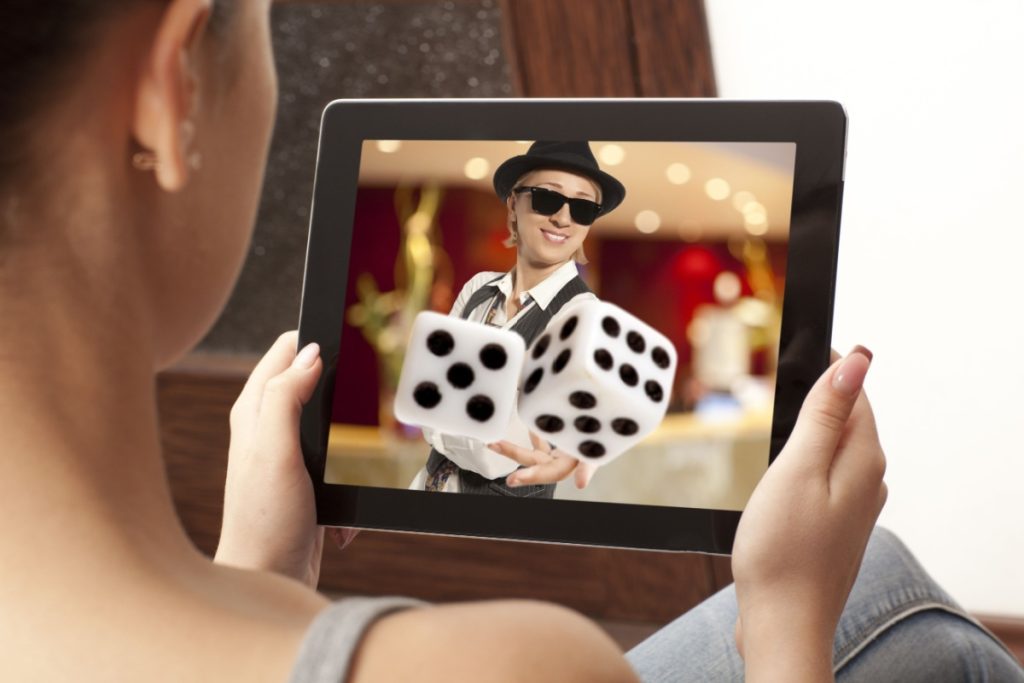 femeie participand la un joc de cazino live online pe tableta, cu un narator carismatic