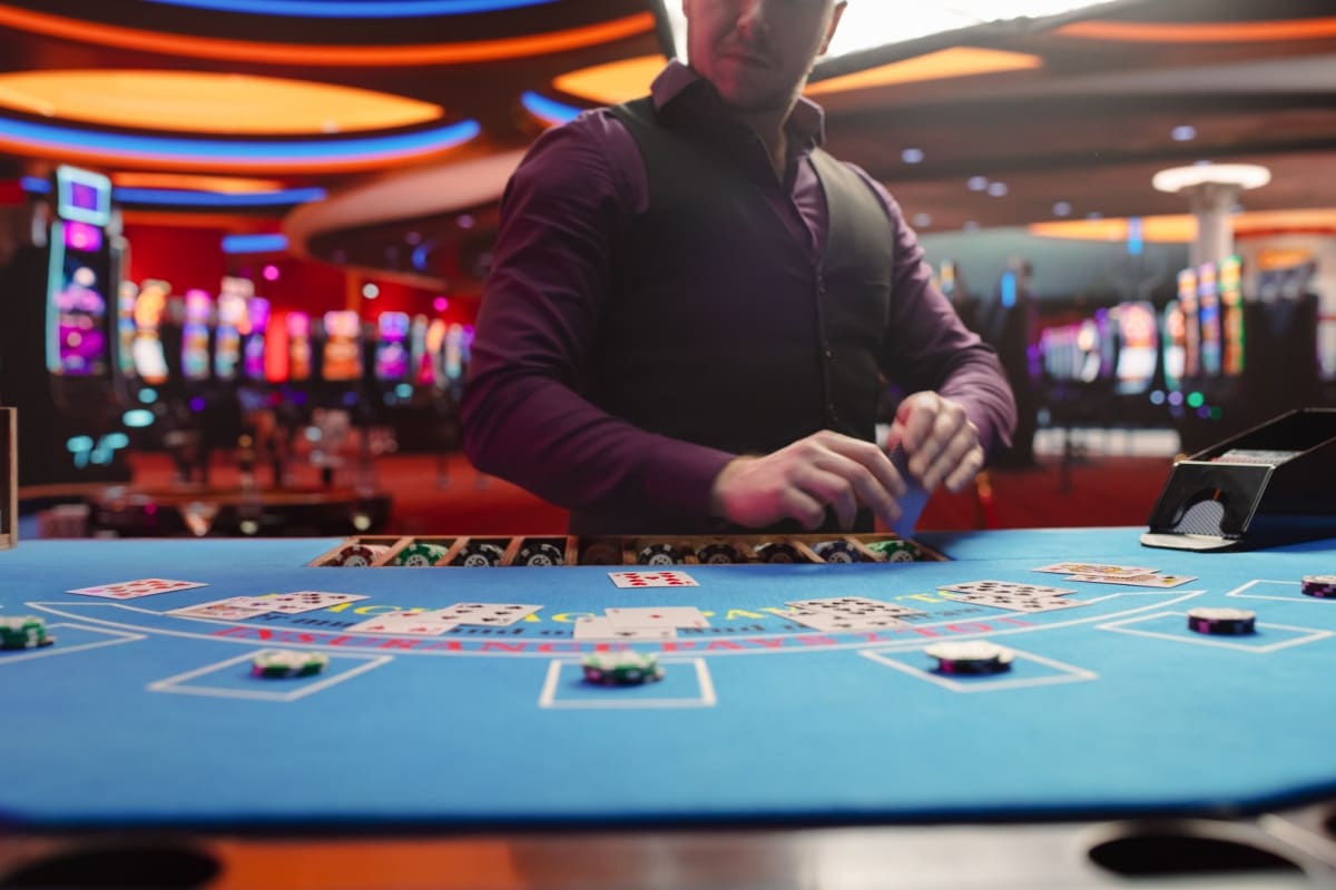 crupier la o masa de cazino live online, plasand cartile jucatorilor