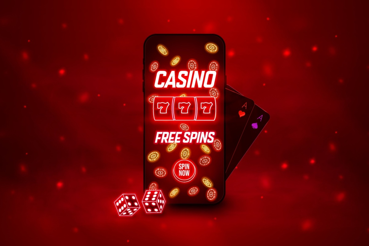 telefon mobil pe care ruleaza o aplicatie de cazino online cu rotiri gratuite, alaturi de carti de joc si zaruri