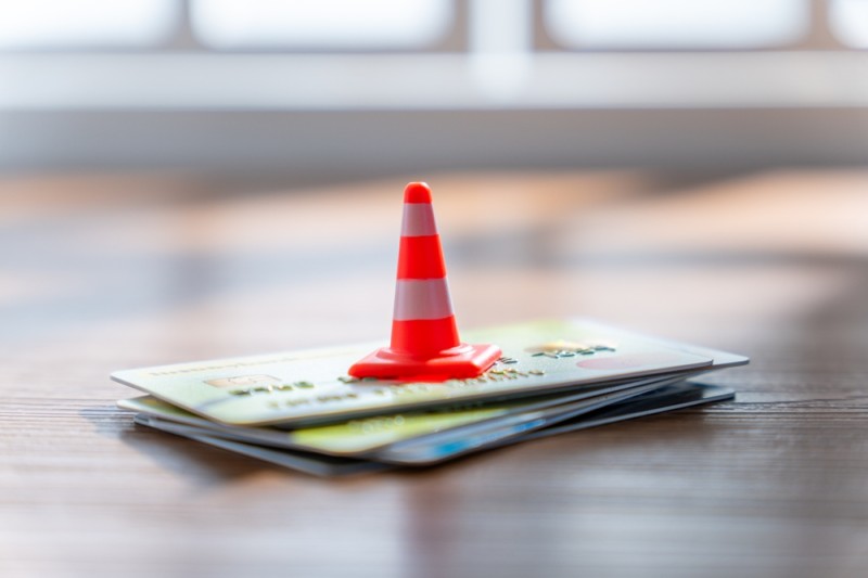 con de trafic in miniatura asezat pe un teanc de carduri, concept limite financiare