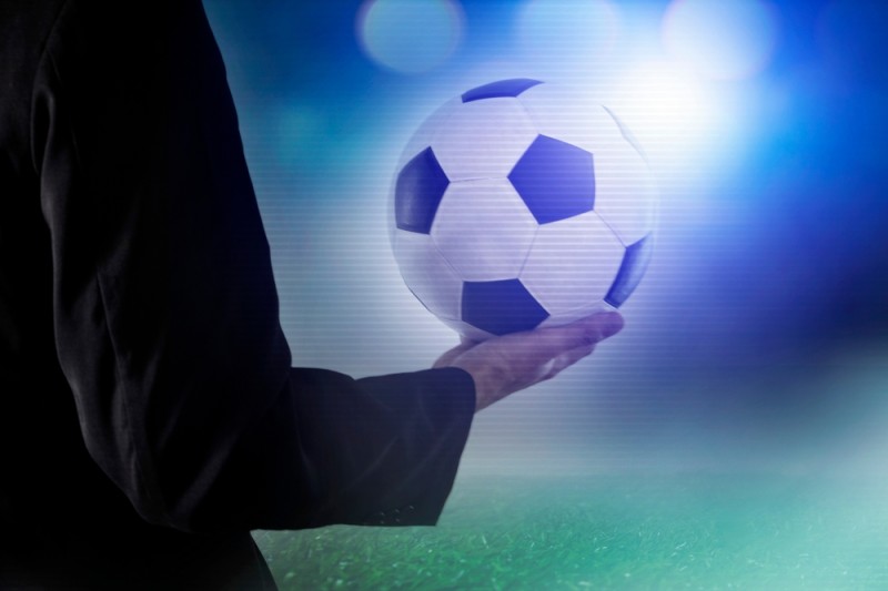 antrenor cu o minge de fotbal in mana