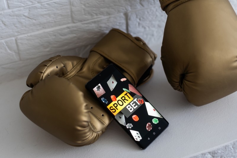 pereche de manusi de box si platforma de pariuri sportive pe telefonul mobil